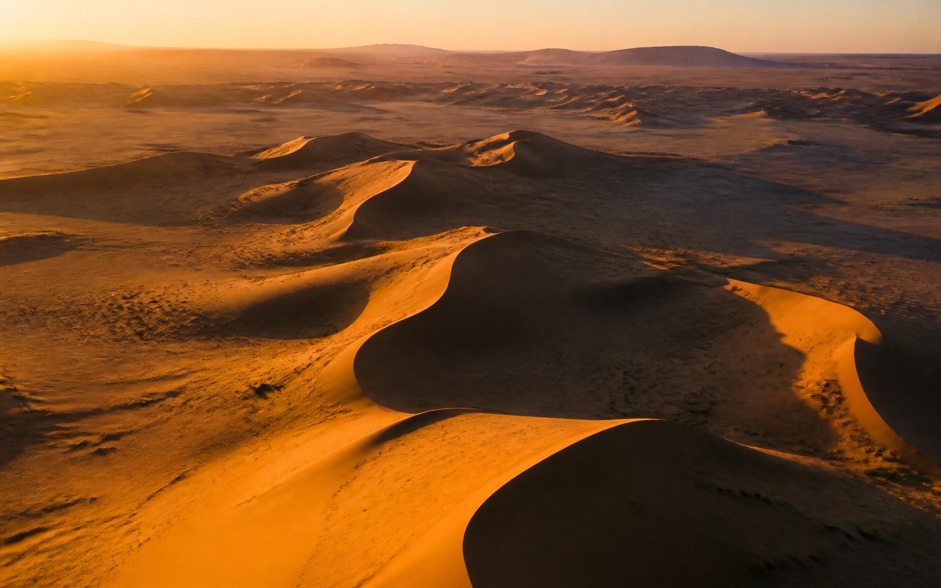 Sahara desert dunes glowing amber at golden hour in southern Morocco